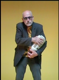 a bald man in a suit is holding a vase